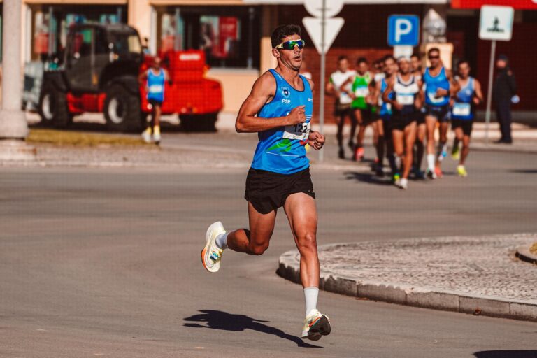 Dynamic image of a male athlete leading a marathon on a sunny day, showcasing determination and endurance.