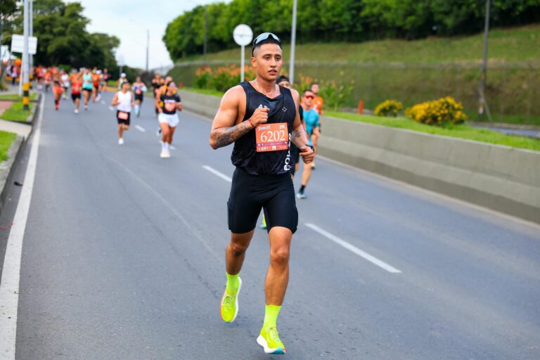 Male athlete in vibrant shoes running in an outdoor marathon.